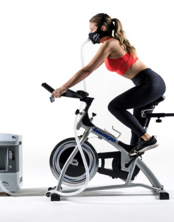 Trainer uses hypoxic machine and mask on cycle...